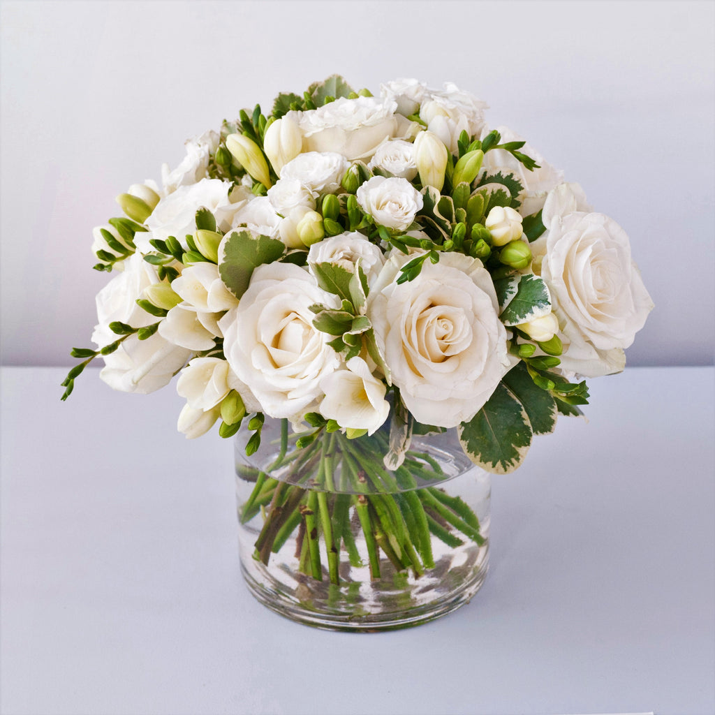 Image of white avalanche roses, white freesias, white spray roses and folisge 