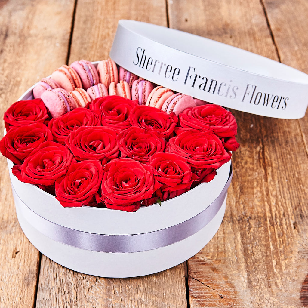 Hat box filled with red roses and macaroons